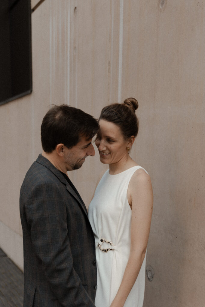 Couple de mariés complices riant et s'enlaçant lors de leur séance photo engagement.