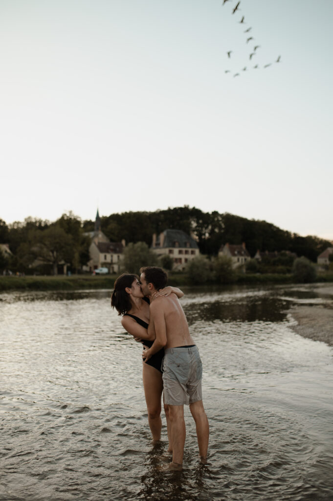 Couple s'embrassant avec tendresse au bord de l'eau.