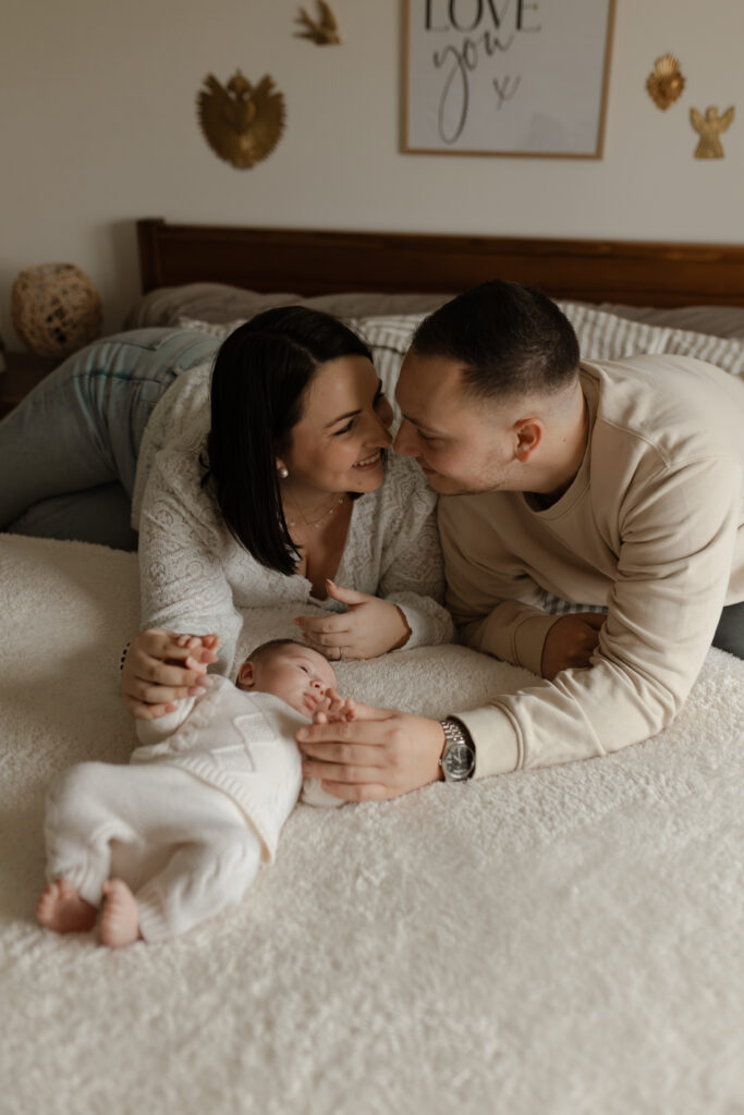 Portrait de famille lifestyle avec un bébé à domicile à Reims, moment câlin.