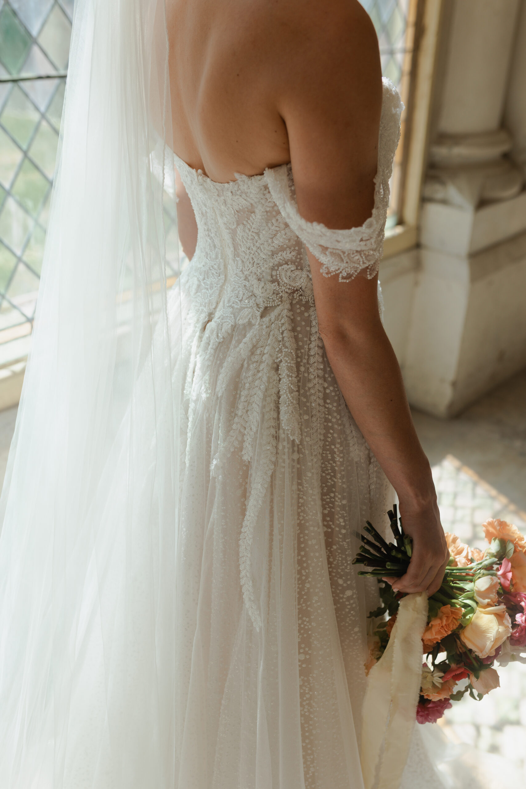 Détail du dos de la robe de mariée et bouquet de fleurs, mariage Dordogne.