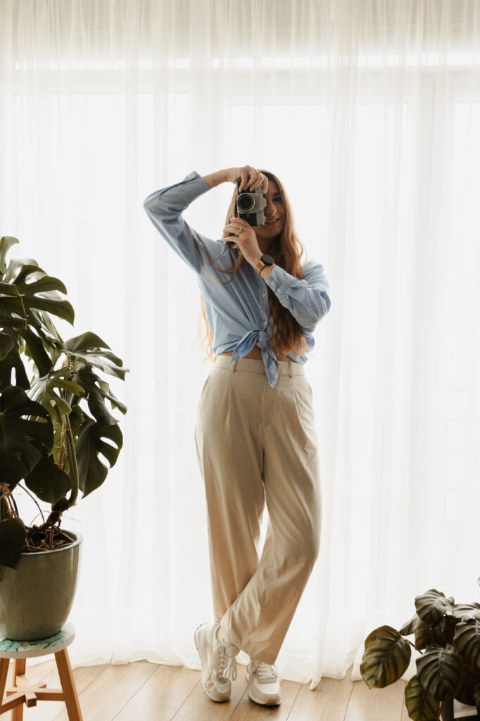 Photographe Reims Clara Martigny avec son boîtier en studio intérieur.
