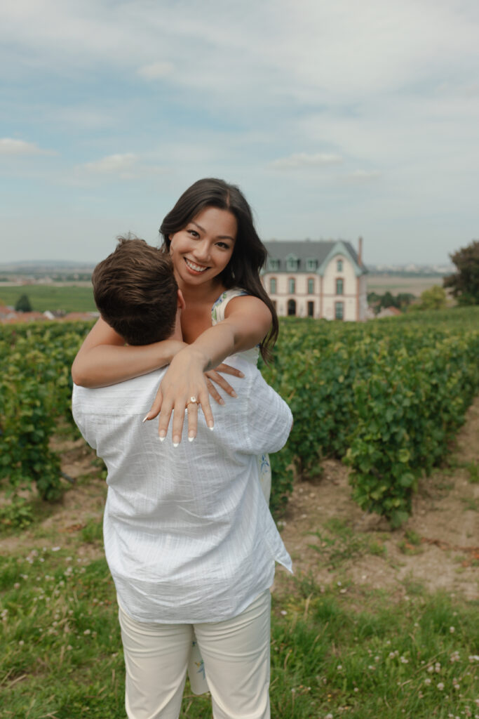 Couple s'enlaçant devant le Château de Sacy, elle tend sa bague pour montrer sa bague de fiançailles.