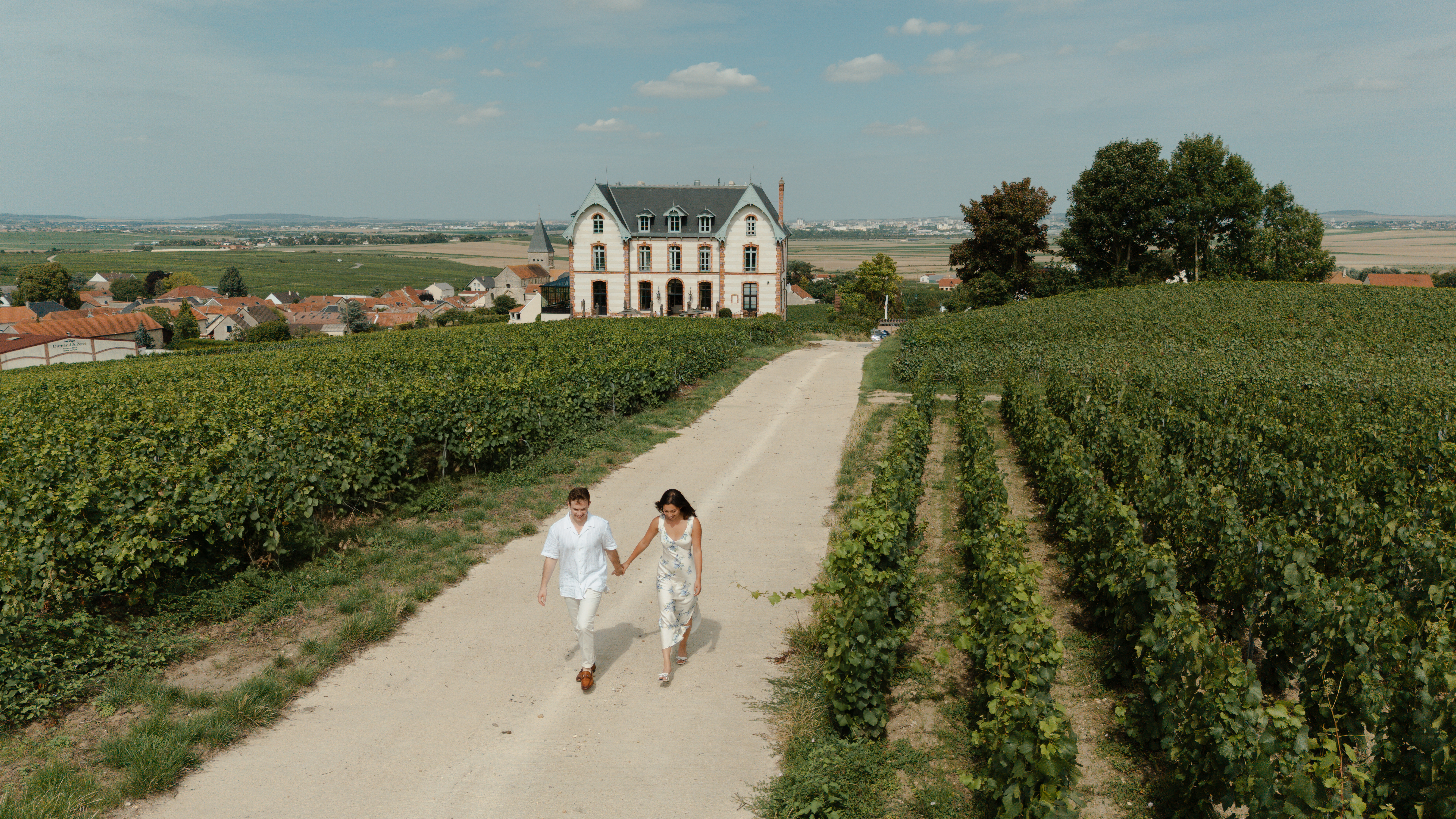 Couple se promenant au milieu des vignes du Château de Sacy.