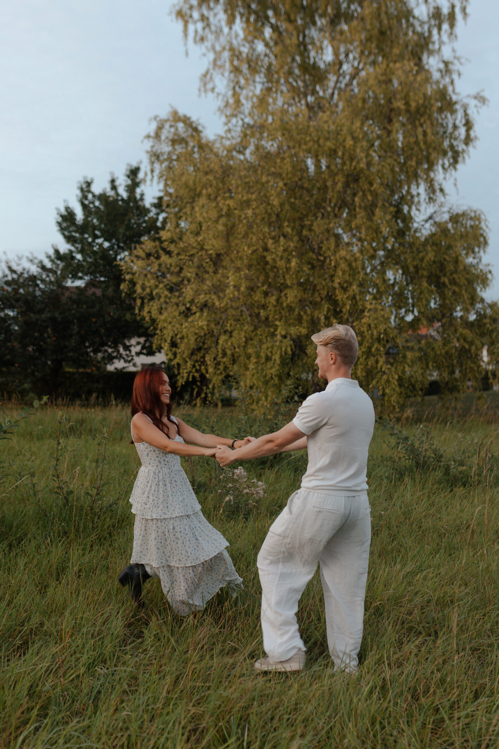 Couple amoureux s'amusant et tournant en rond dans un champ au coucher du soleil à Reims, Champagne Ardenne.