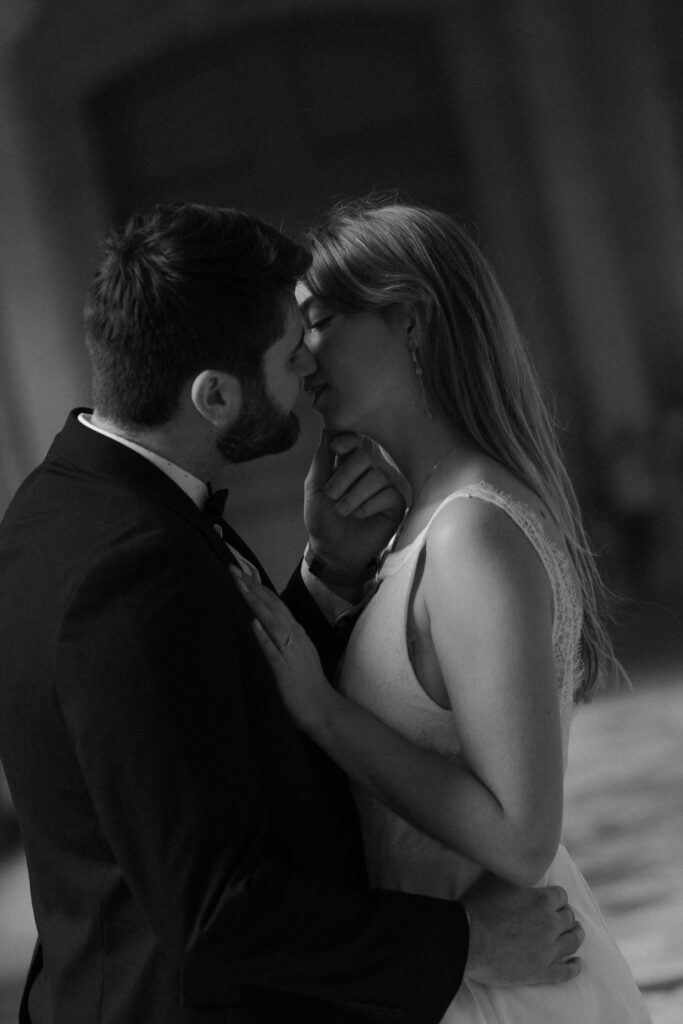 Portrait intime en noir et blanc d'un couple de mariés se préparant à s'embrasser.