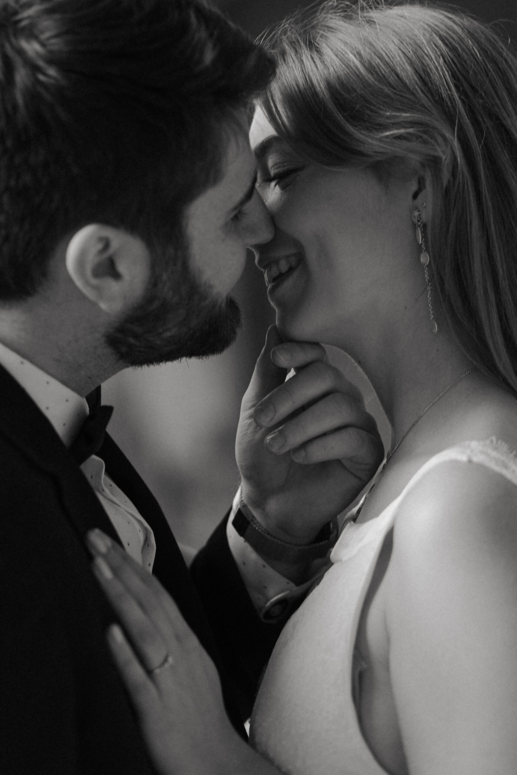 Portrait de couple en noir et blanc de profil, s'embrassant avec douceur, style intime.