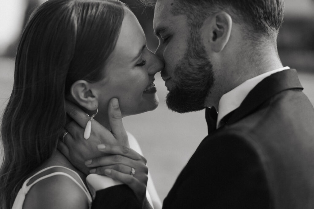 Plan rapproché des mariés s'embrassant en noir et blanc, photo mariage Reims.
