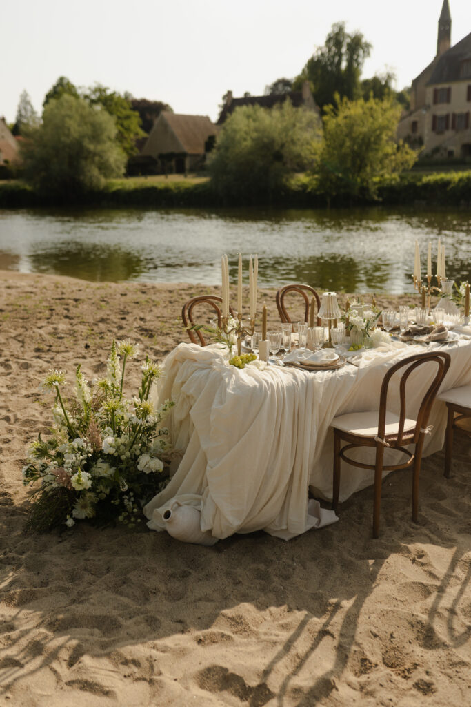 Table de mariage décorée en extérieur sur une plage de rivière près de Reims.
