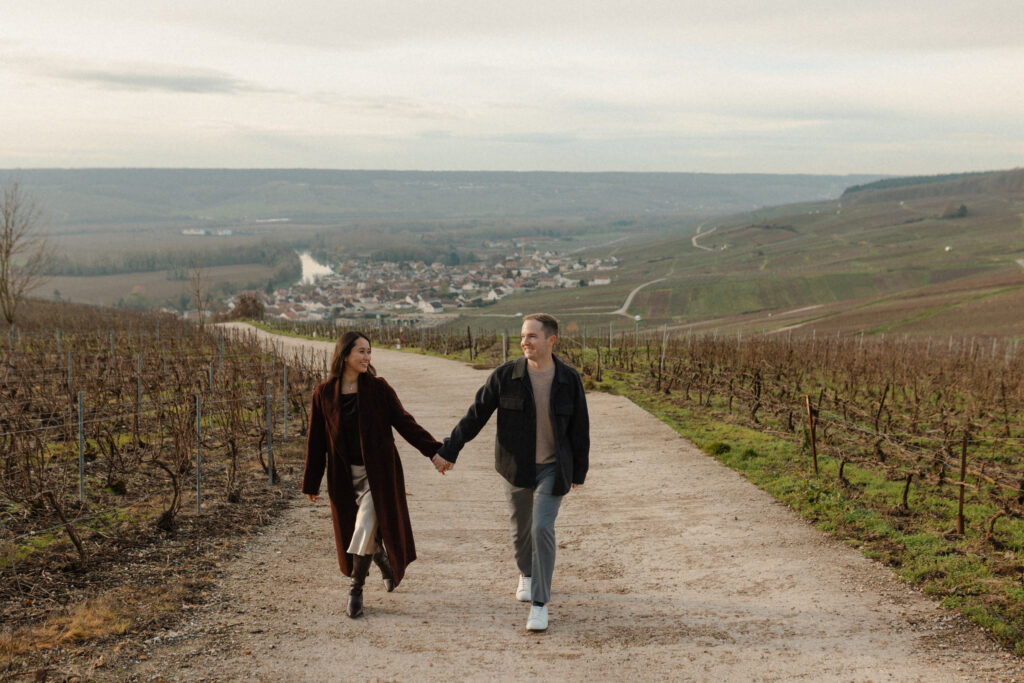 Couple marchant main dans la main dans le vignoble champenois.