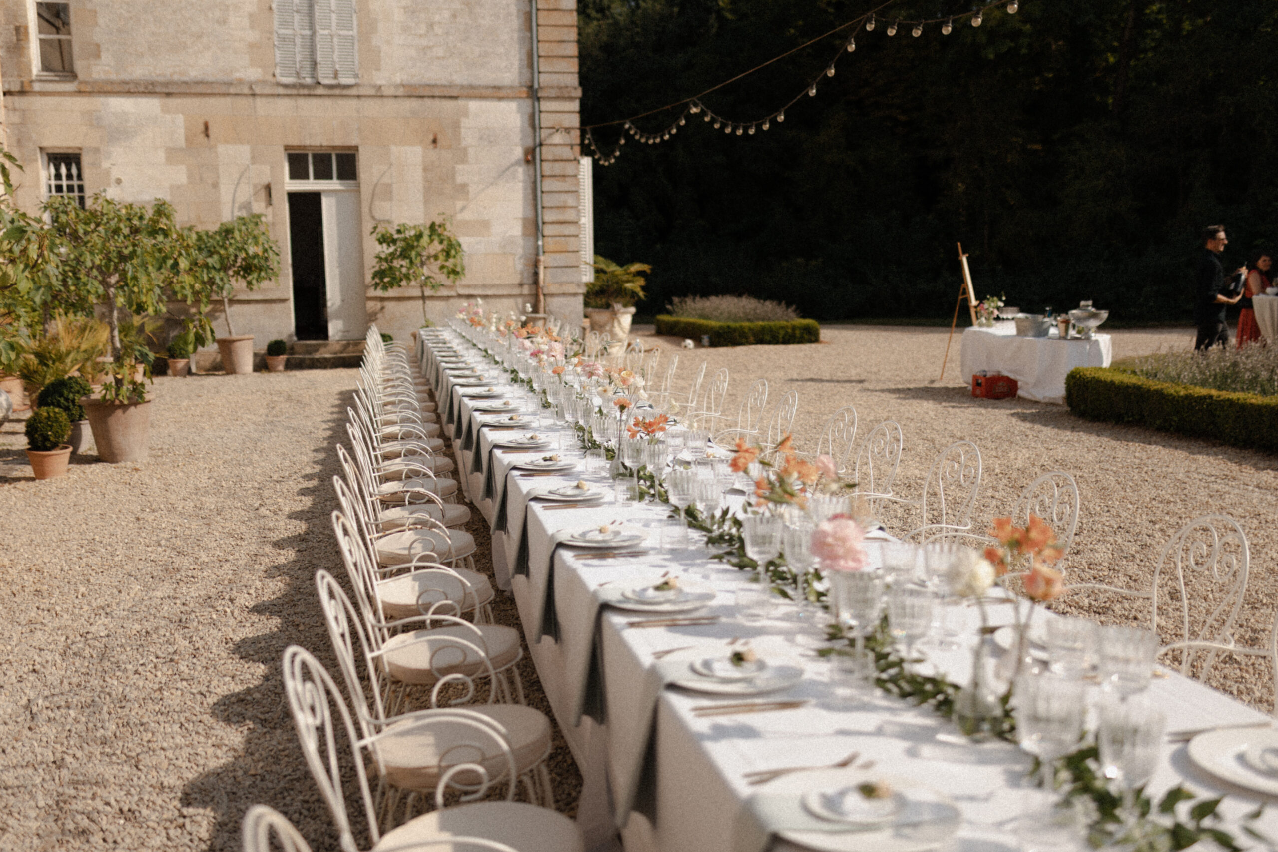 Perspective d'une tablée de mariage au Château de Mairy avec une décoration florale aux couleurs du printemps.