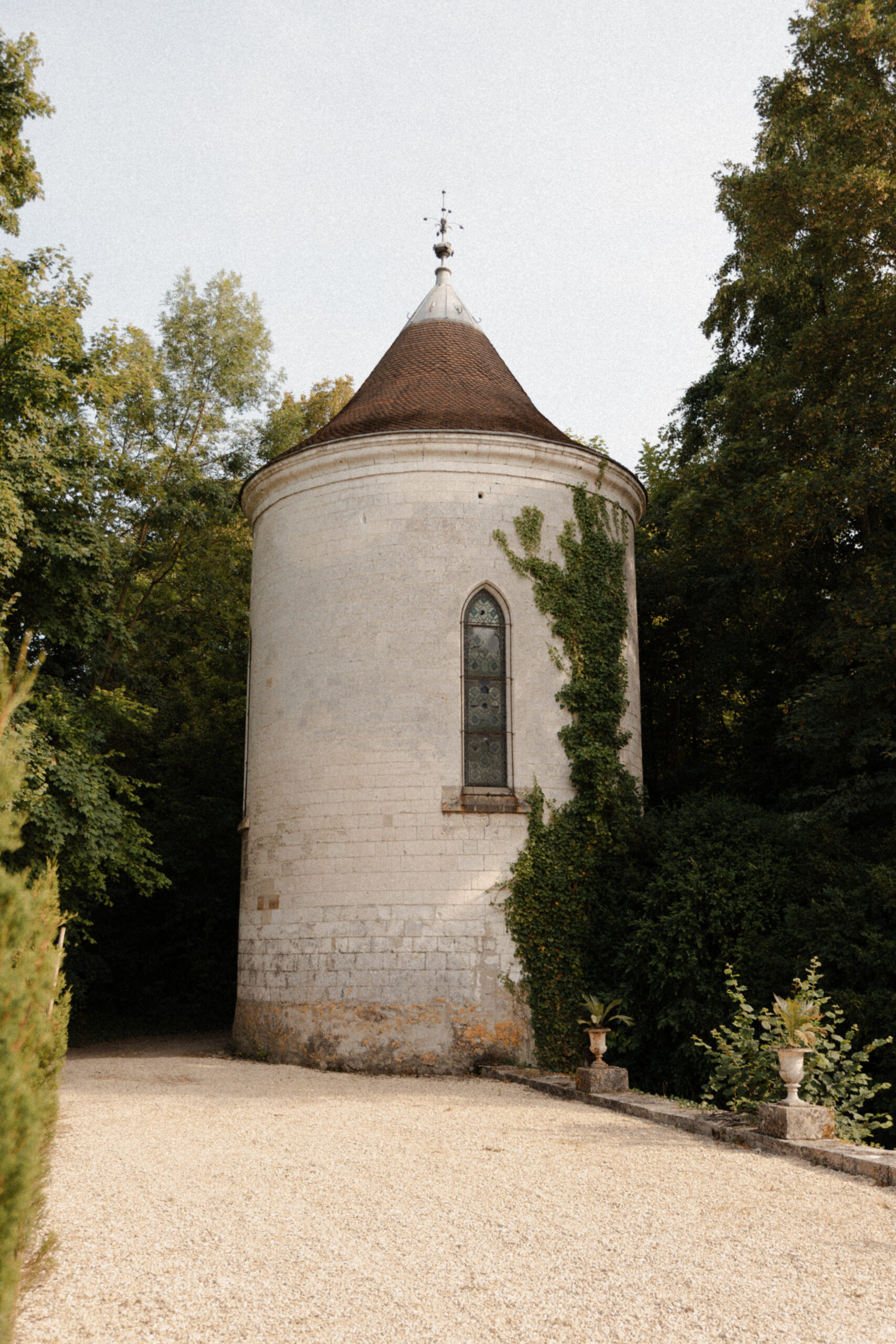 Vue de la tour de la chapelle du Château de Mairy nichée dans la végétation du parc.