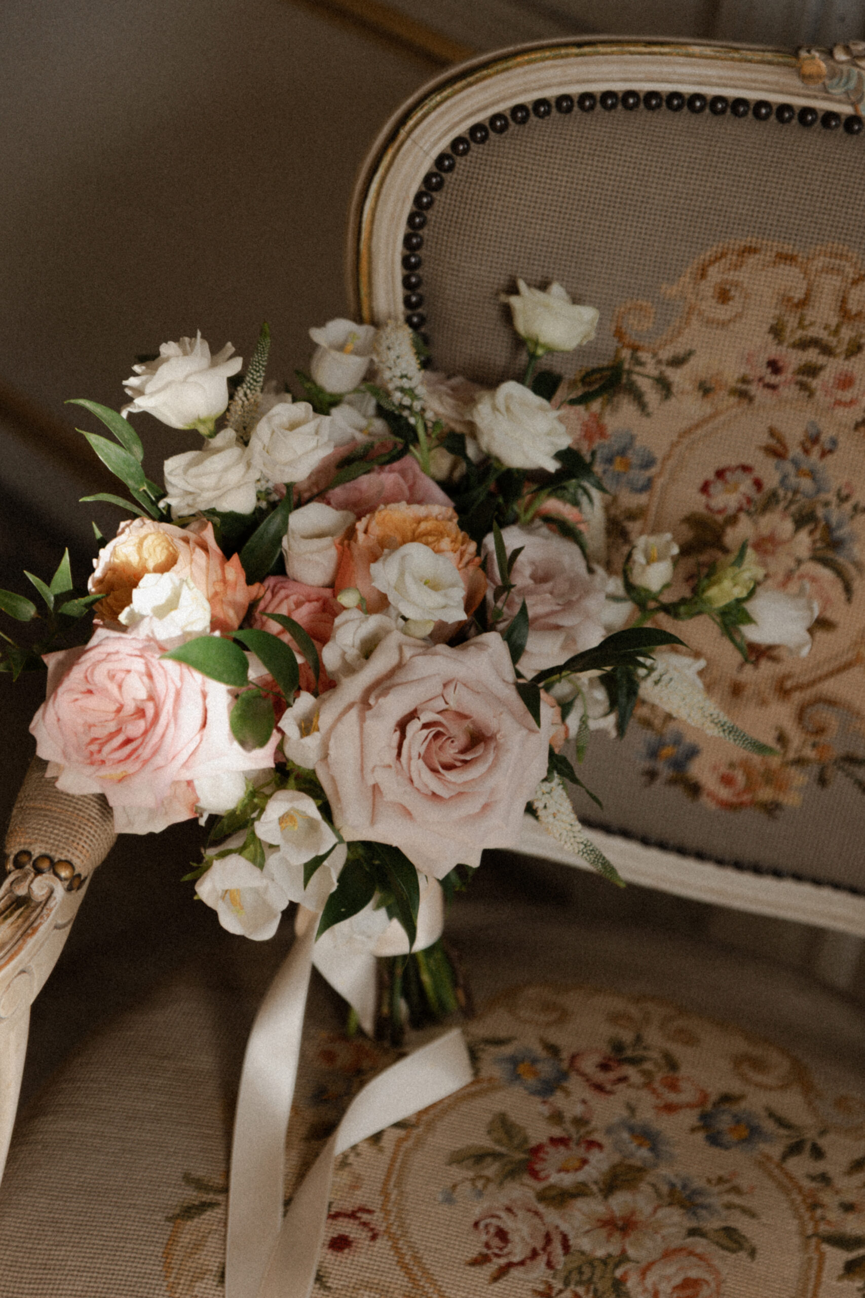 Bouquet de mariée style Fine Art posé sur un fauteuil d'époque dans un salon du Château de Mairy.