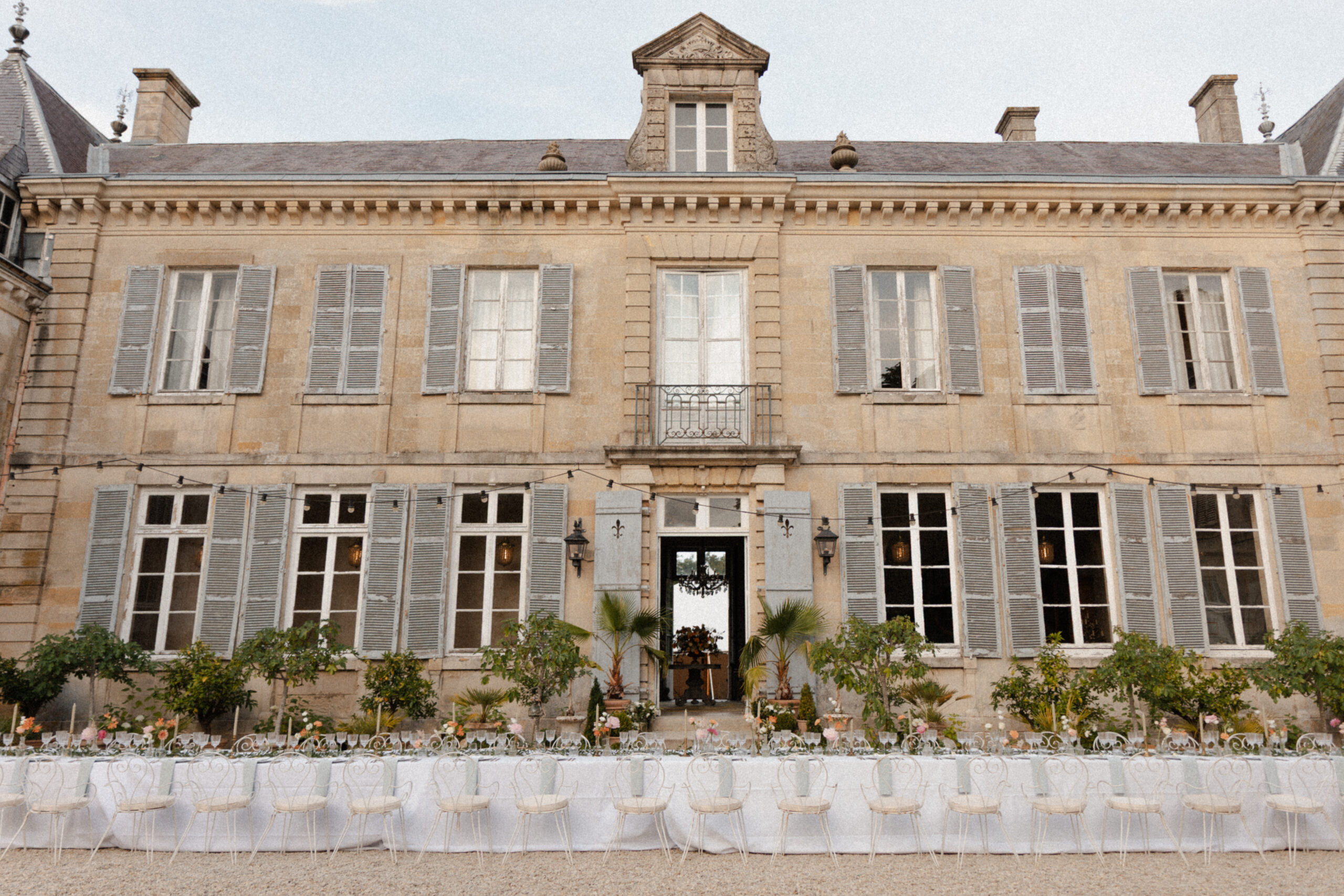 Table de banquet de mariage installée devant le Château de Mairy. Style chic à la française, domaine mariage Reims Champagne.