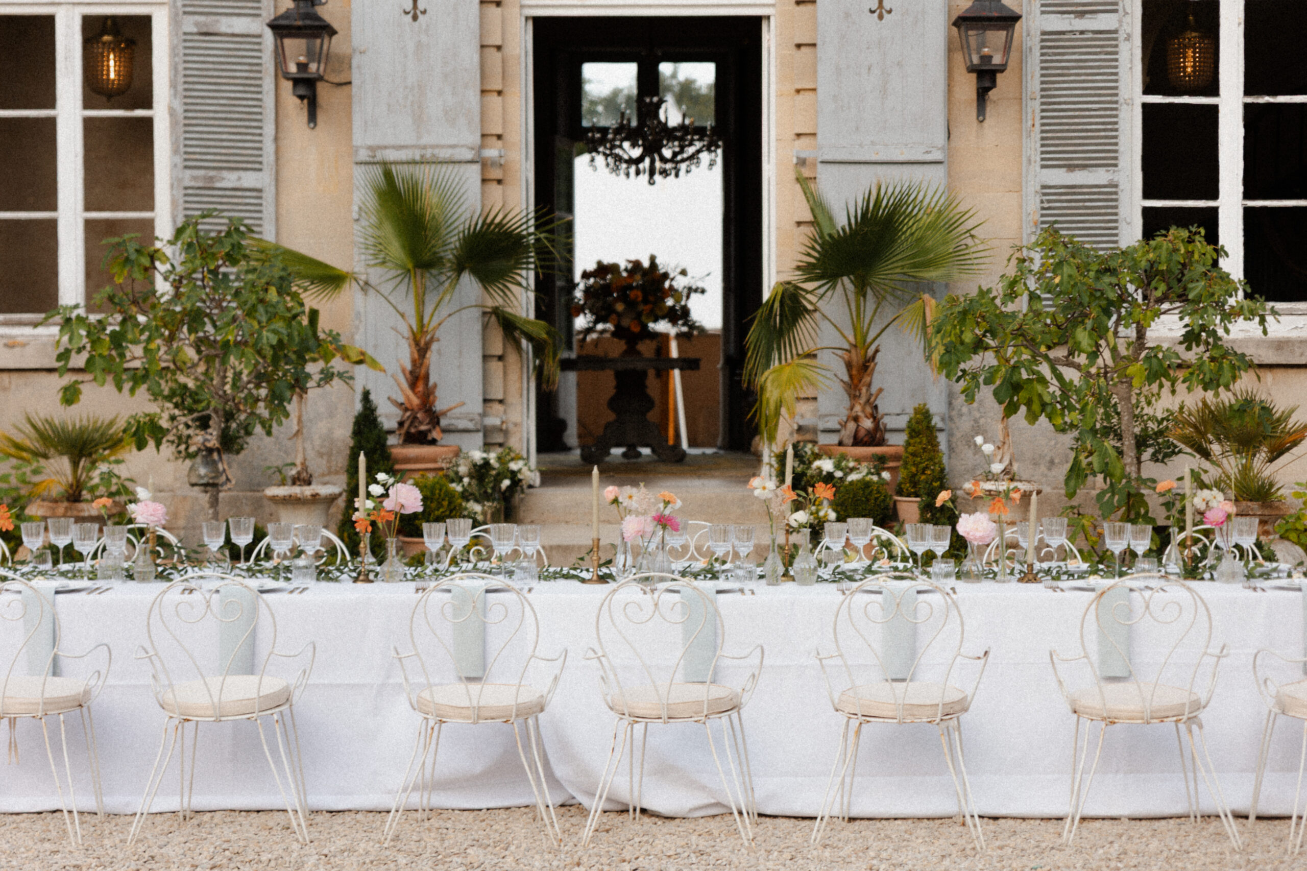 Photo rapprochée d'une table dressée face à la façade du Château de Mairy, domaine mariage Reims.