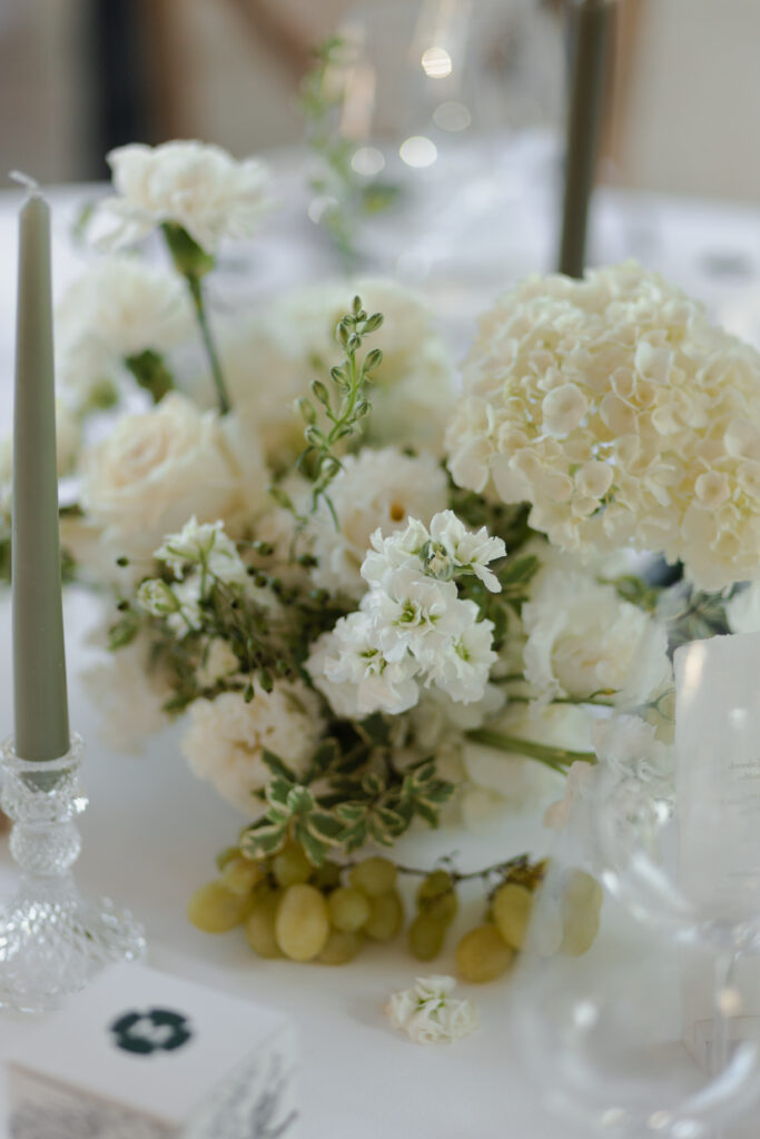 Détail d'une table avec raisins et bougies, décoration mariage haut de gamme à Reims, Domaine de Vaugency.