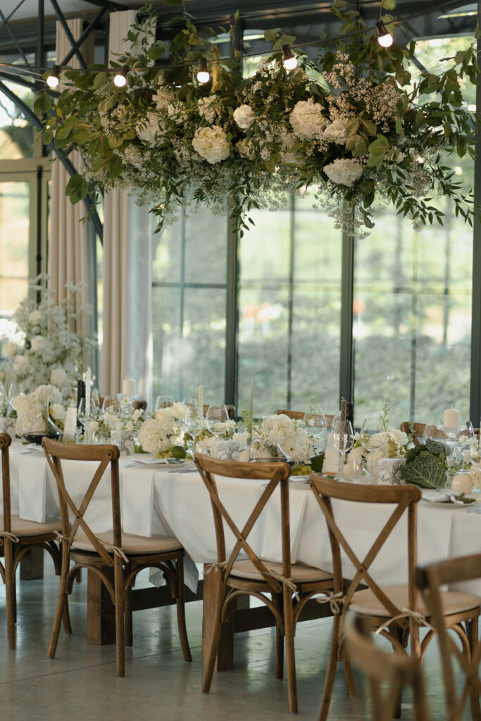 Longue table de banquet fleurie dans l'Orangerie du Domaine de Vaugency, style Bridgerton.