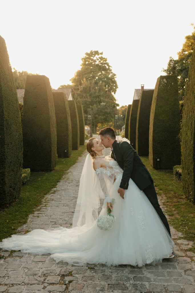 Photo de couple dans l'allée centrale des buis du Domaine de Vaugency au coucher du soleil.