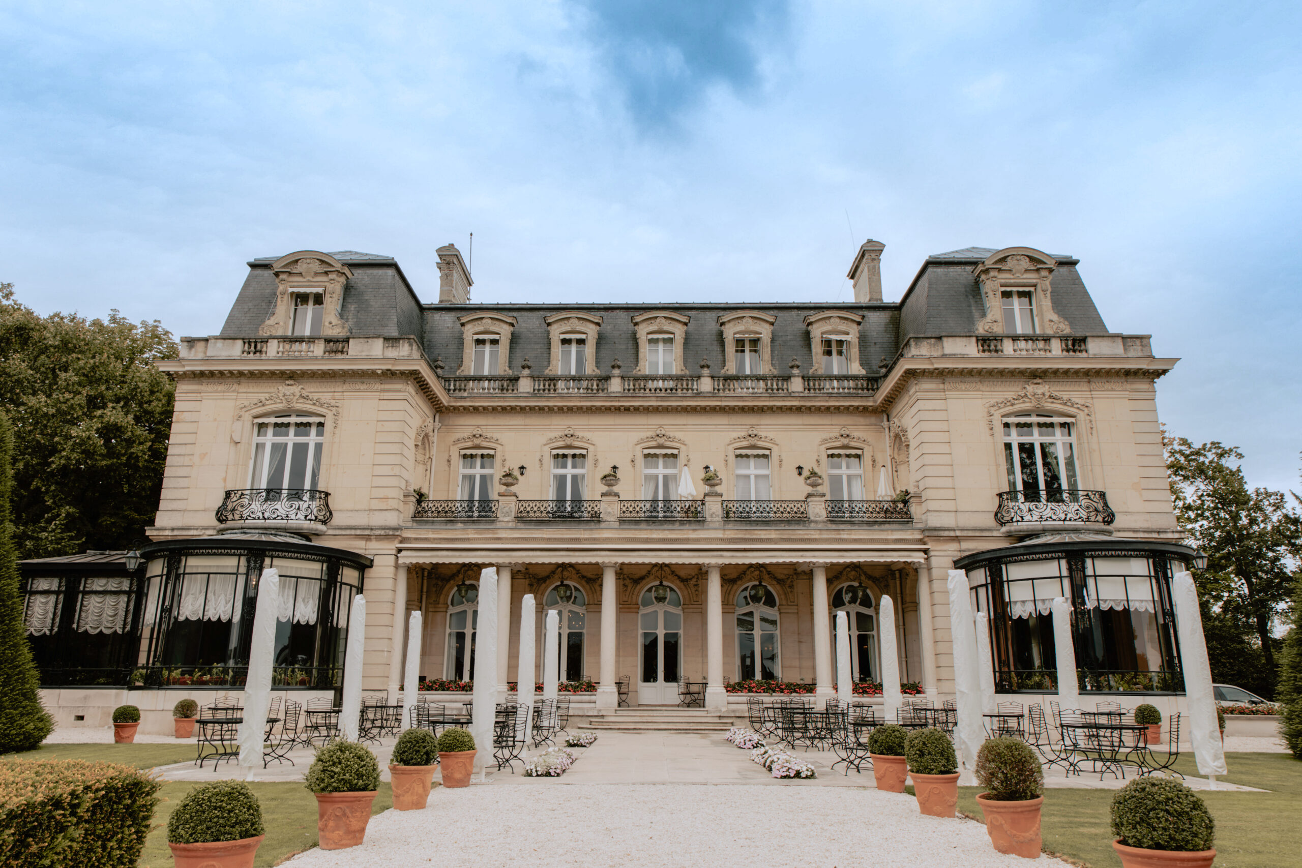 Photographie du magnifique Château du Domaine des Crayères à Reims, en Champagne. Vue extérieure du château entouré d'un parc arboré, idéal pour un mariage de luxe et prestigieux près de Reims.