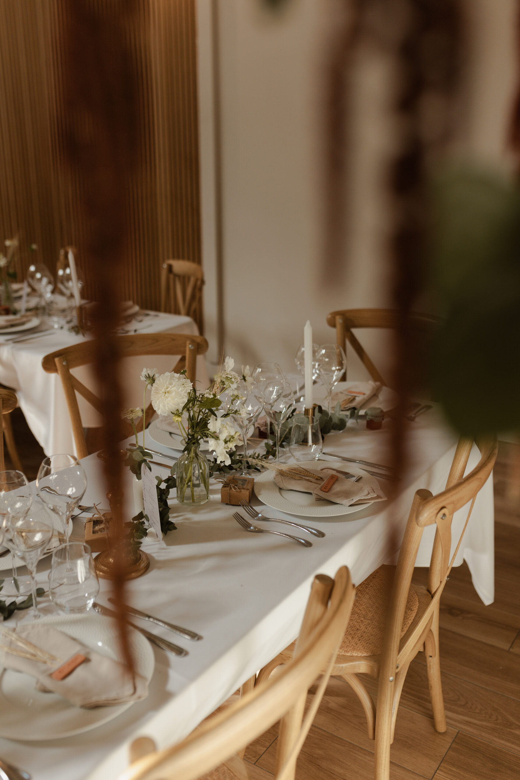 Gros plan en couleur sur une table d'honneur de mariage au Domaine de La Closeraie. La photo, prise en plongée rapprochée, met en valeur les compositions élégantes.