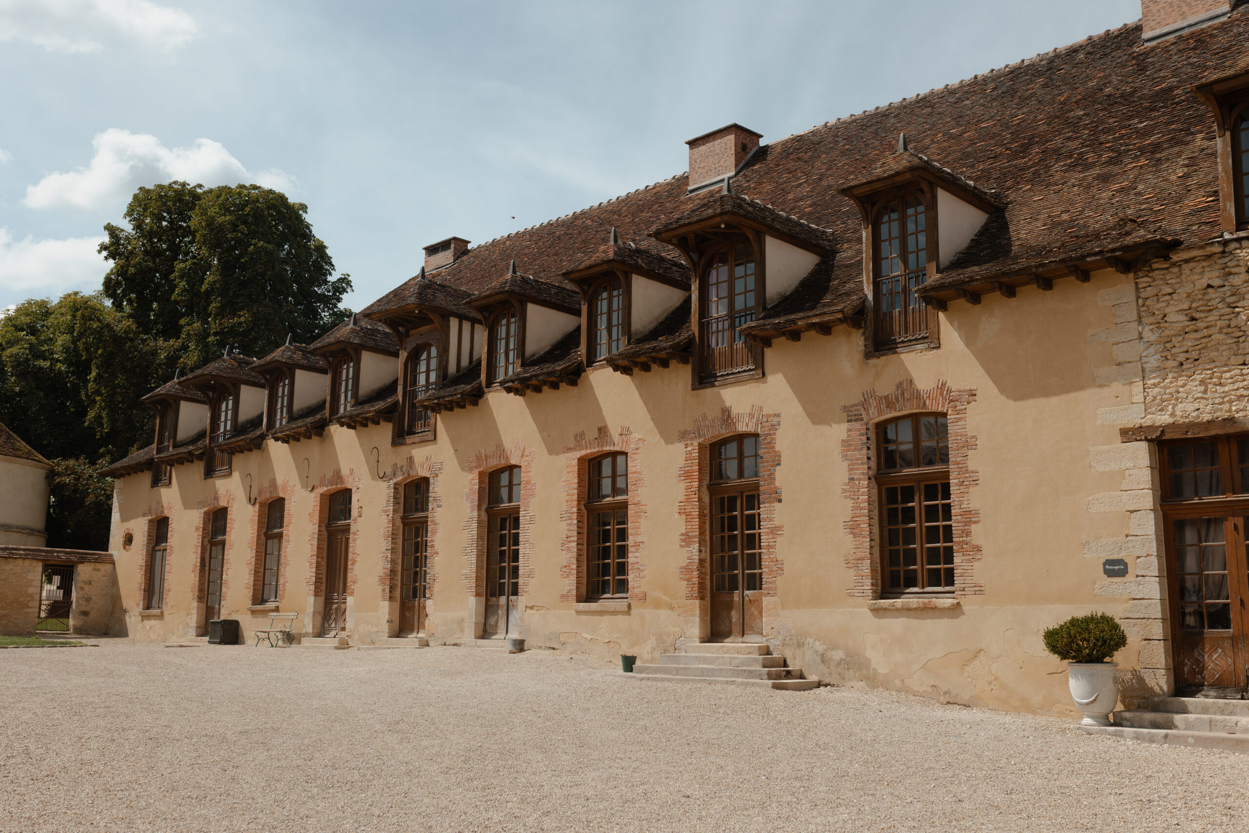Façade de la grange de réception photographiée depuis le sol sous un plein soleil.