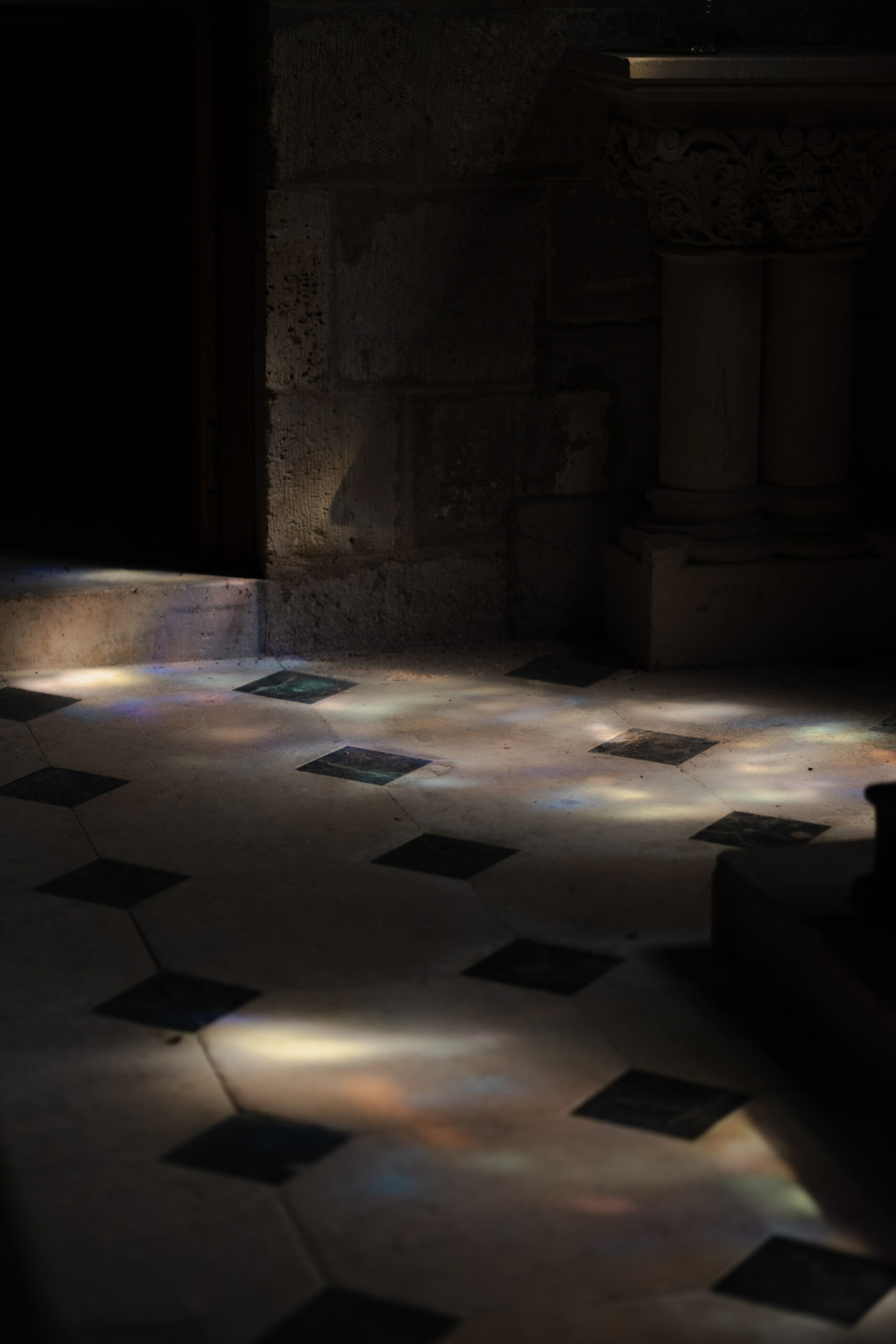 Reflets colorés des vitraux sur le sol en damier de l'église au Prieuré de Binson, domaine mariage Reims.