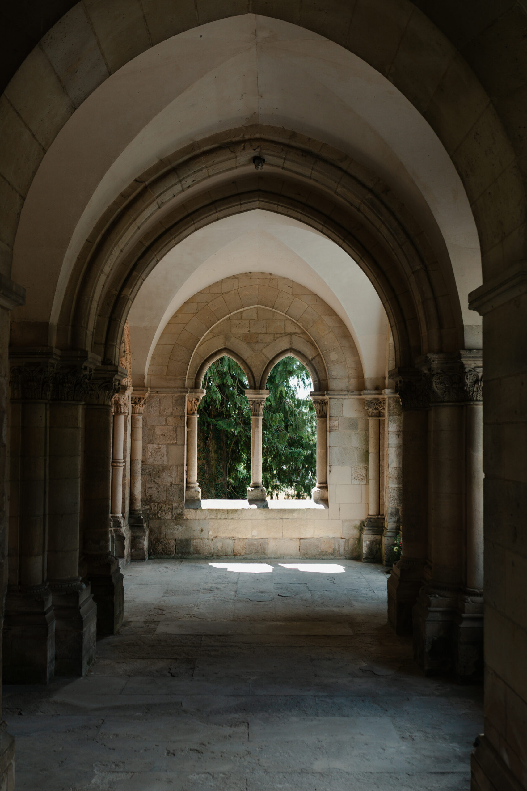 Photographie des arches voûtées du porche de l'église au Prieuré de Binson, domaine mariage Reims Champagne. Vue intérieure sur une fenêtre historique.