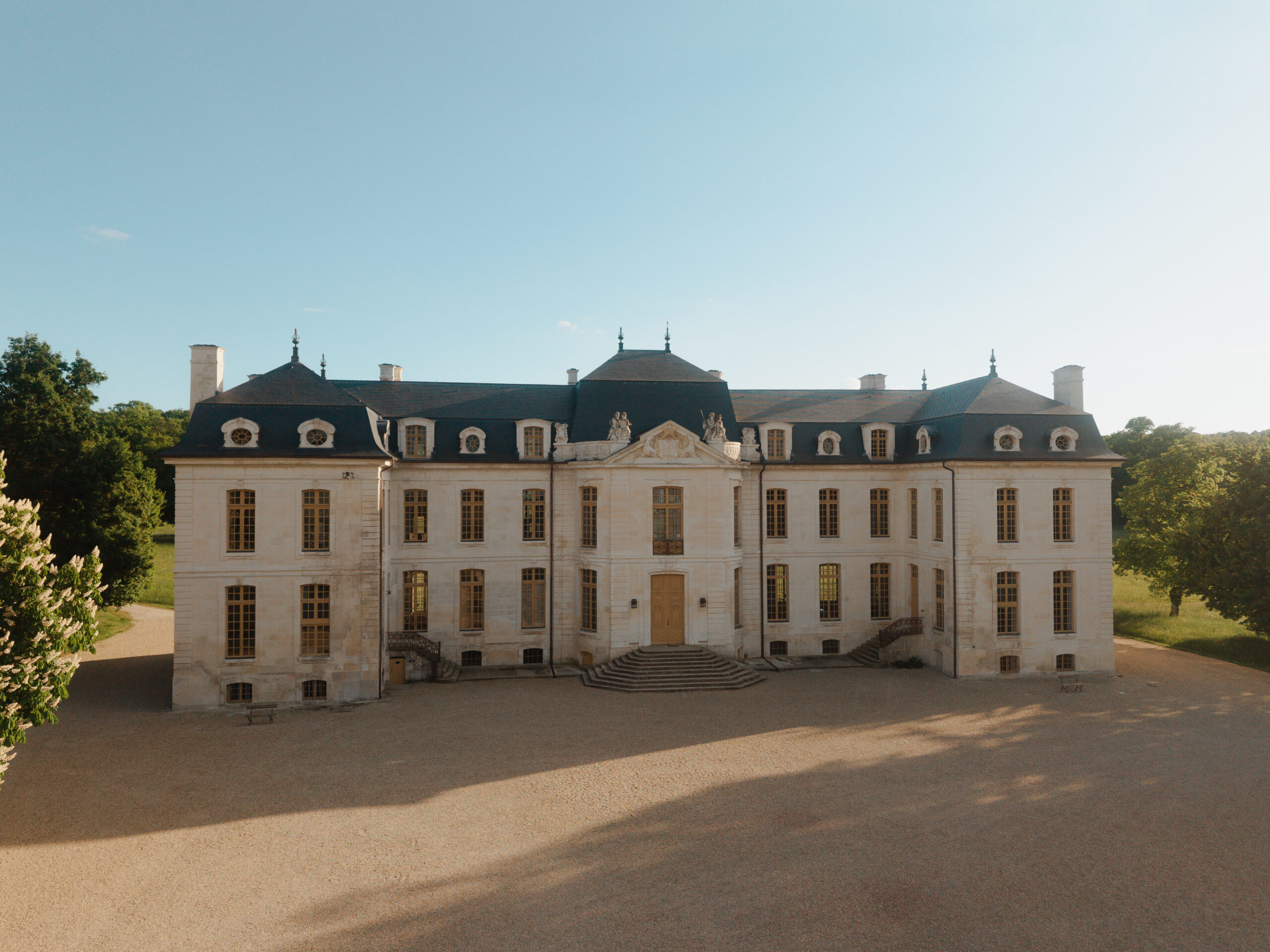 Prise de vue aérienne centrée sur le Château de Vaux sous une lumière zénithale.