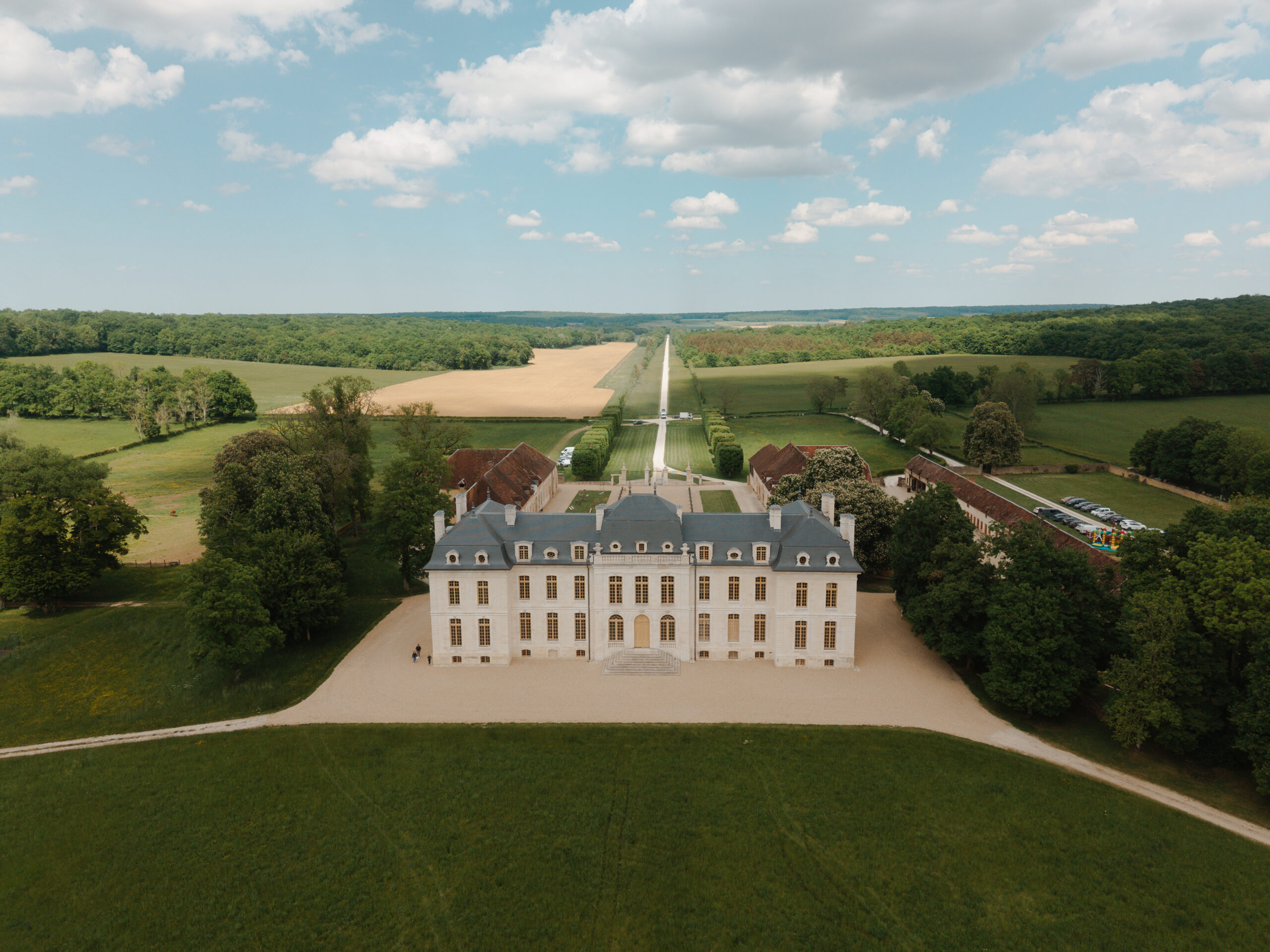 Vue au drone de l'arrière du Château de Vaux montrant le long chemin privé et l'immensité du domaine.