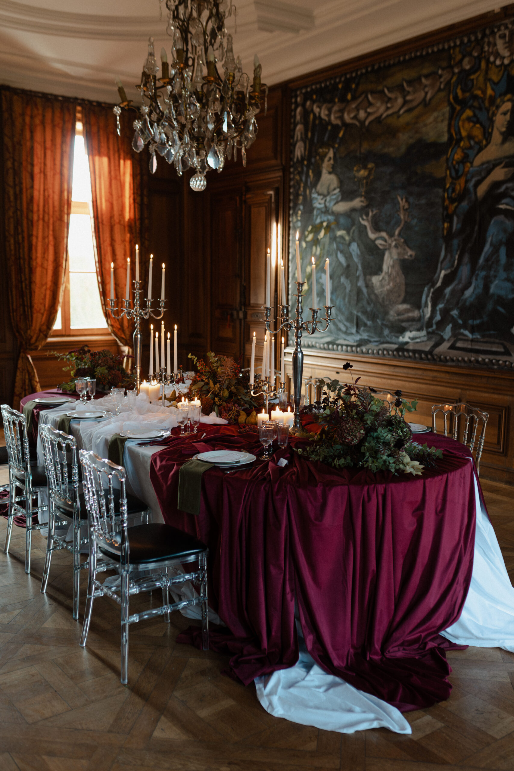 Décoration de table thème baroque bordeaux (shooting Novera) dans un salon boisé avec peinture au mur.