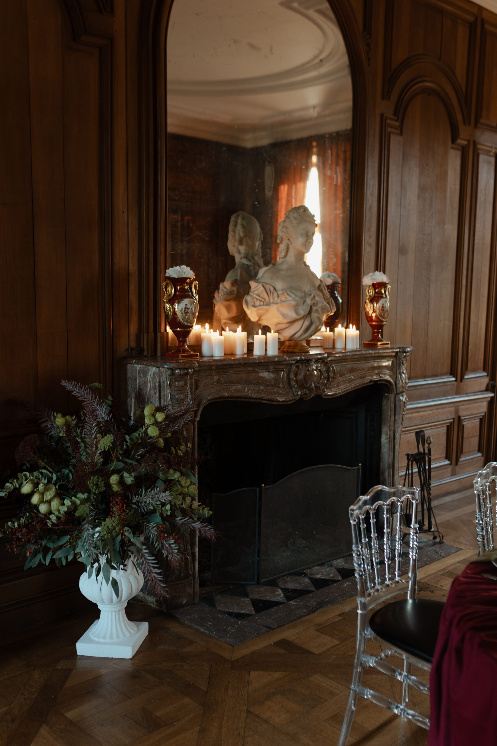 Détail d'une cheminée en marbre avec miroir, buste sculpté et bougies allumées au Château de Vitry-la-Ville.
