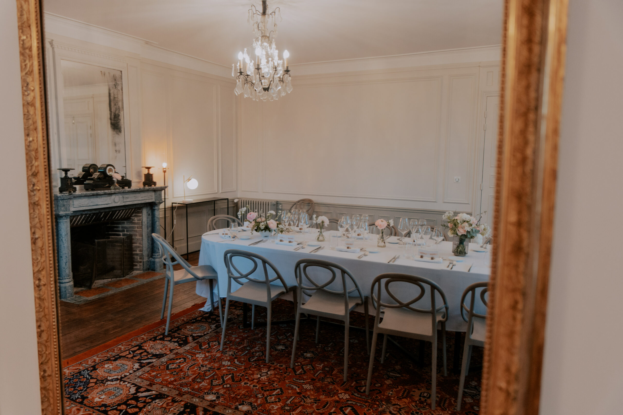 Photo de la table de réception de mariage prise dans le reflet d'un miroir ancien au Château de Cormicy.