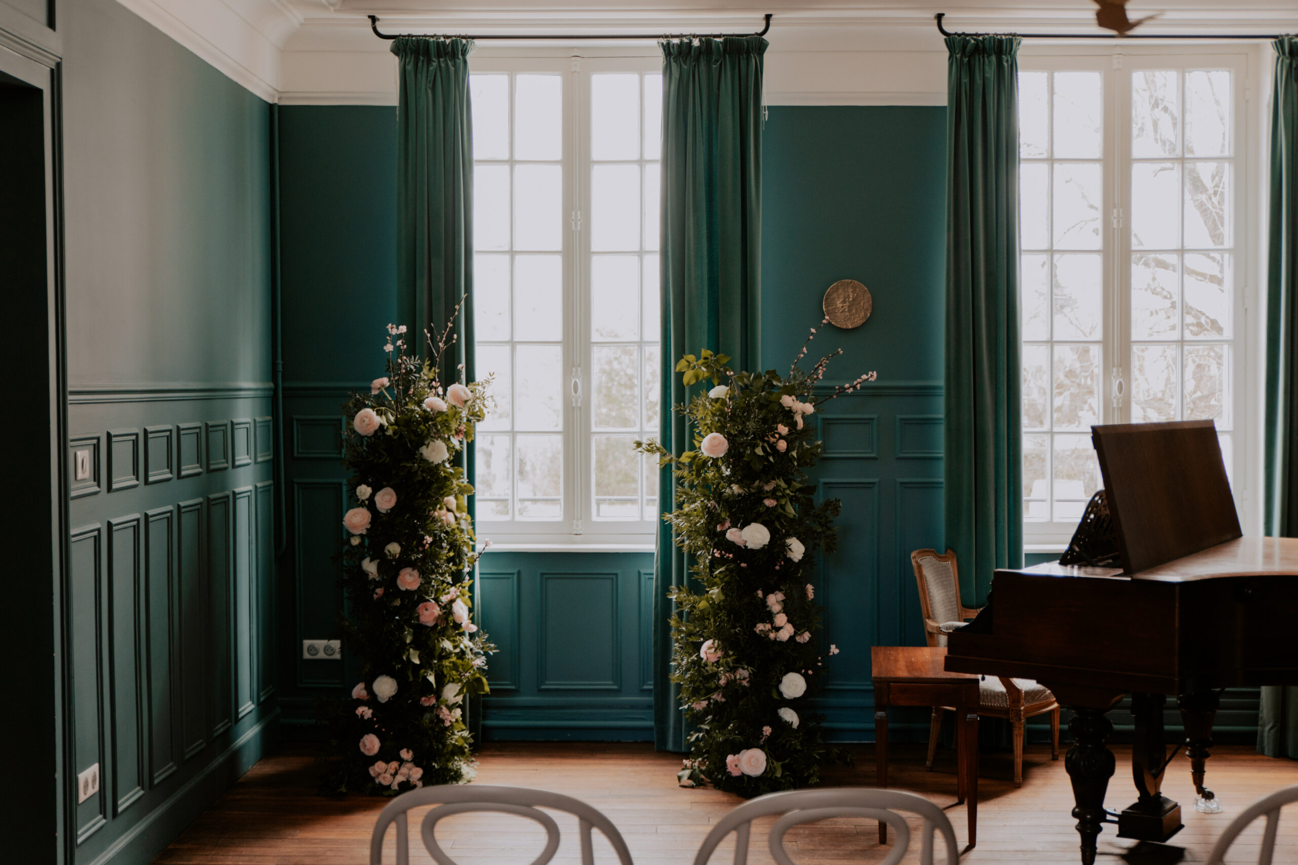 Gros plan sur une arche asymétrique florale signée Histoires Sauvages pour une cérémonie laïque dans le salon bleu du Château de Cormicy.