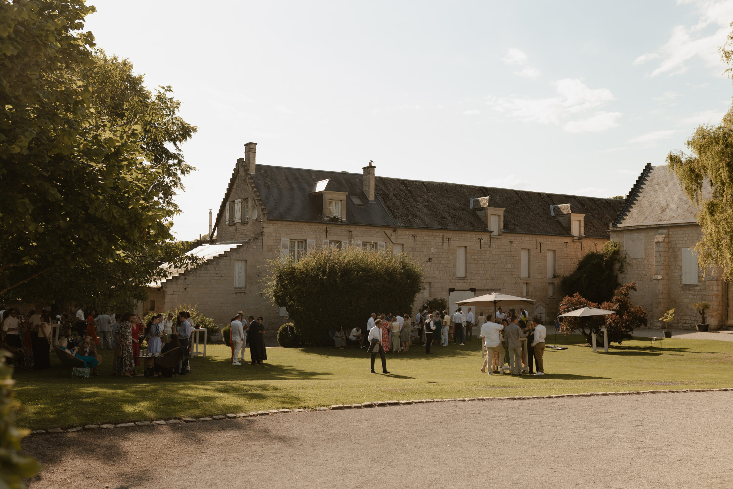 Autre vue du vin d'honneur extérieur aux Pommerieux, ambiance lumineuse et festive.