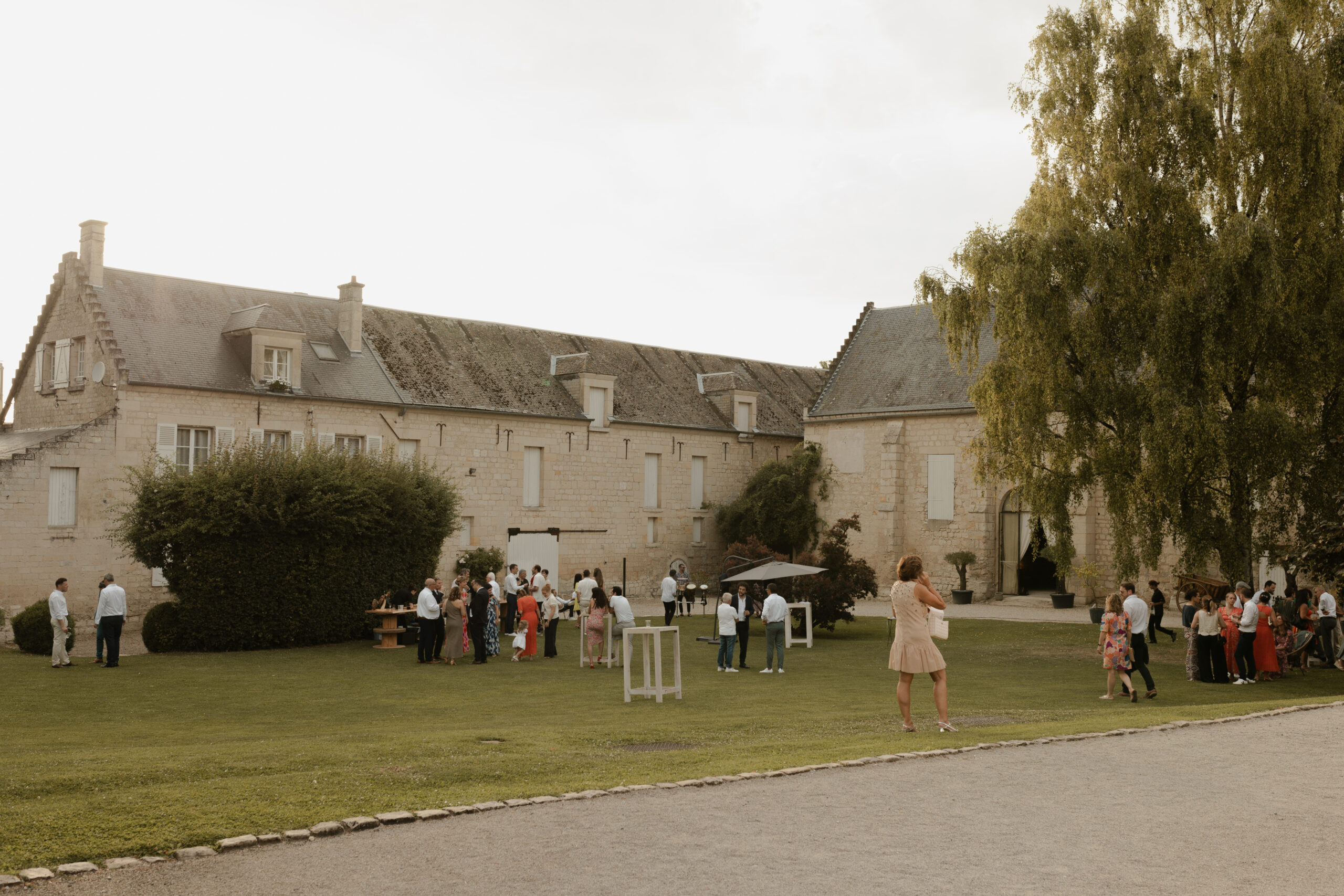 Cocktail de mariage en extérieur sur la pelouse du domaine Les Pommerieux sous un soleil d'été.