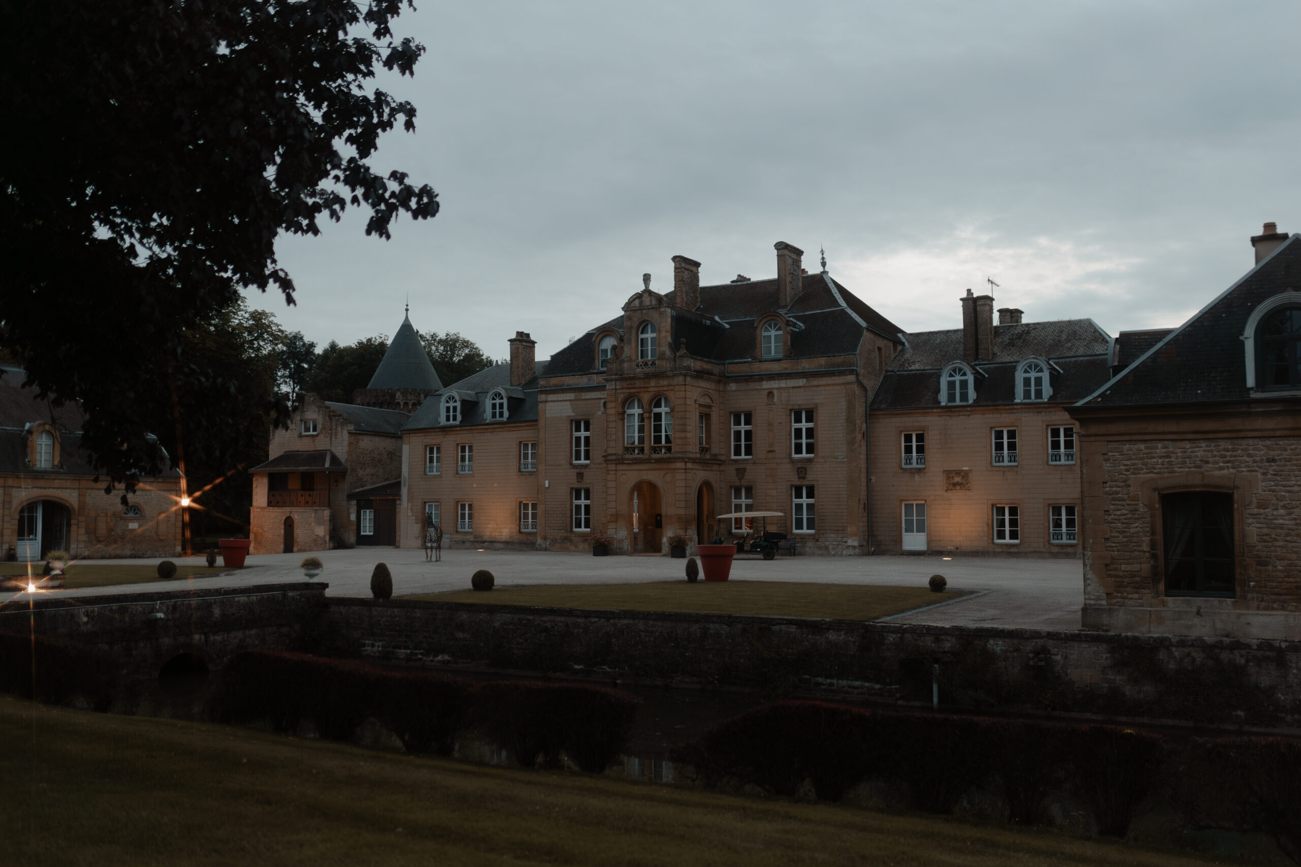 Façade avant du Château du Faucon illuminée pour une soirée de mariage.