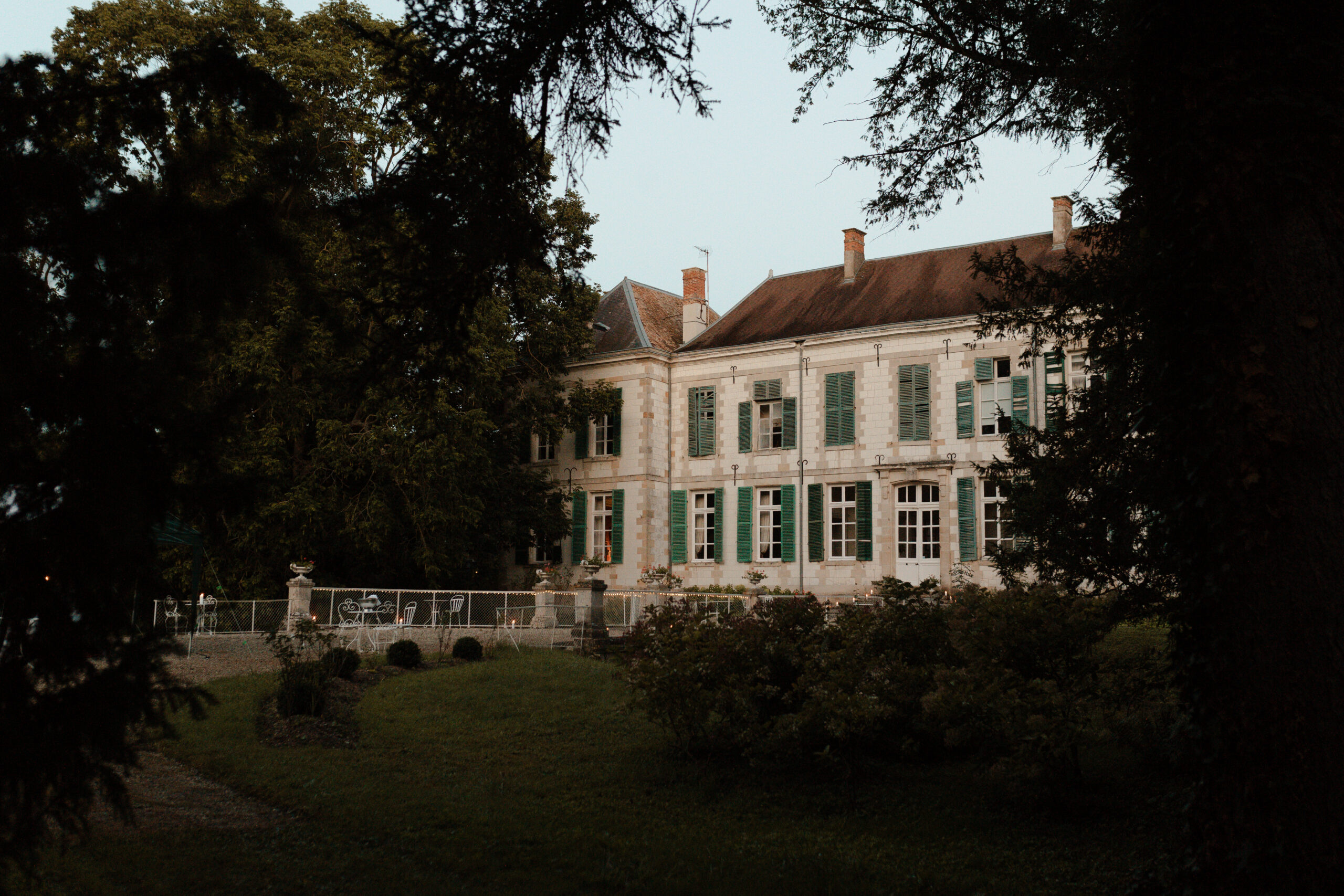 Vue d'ensemble du Château de Juvigny entouré de grands arbres, domaine mariage Reims Champagne.