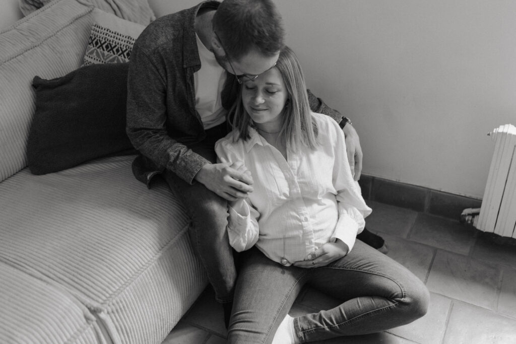 Couple dans un cocon intimiste à Reims : papa embrassant la maman sur la tête, photo en noir et blanc.