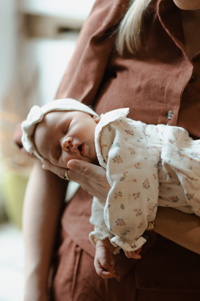 Bébé endormi sur le bras de sa maman, bras ballants, photo très mignonne à Reims.