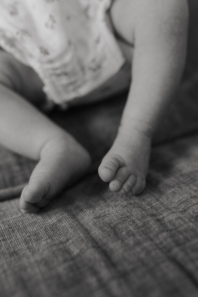 Photo macro des pieds d'un bébé allongé sur le canapé, en noir et blanc à Reims.