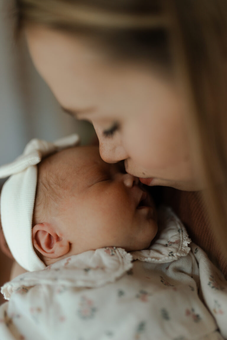 Gros plan macro de maman embrassant le nez de son bébé, moment intime à Reims.