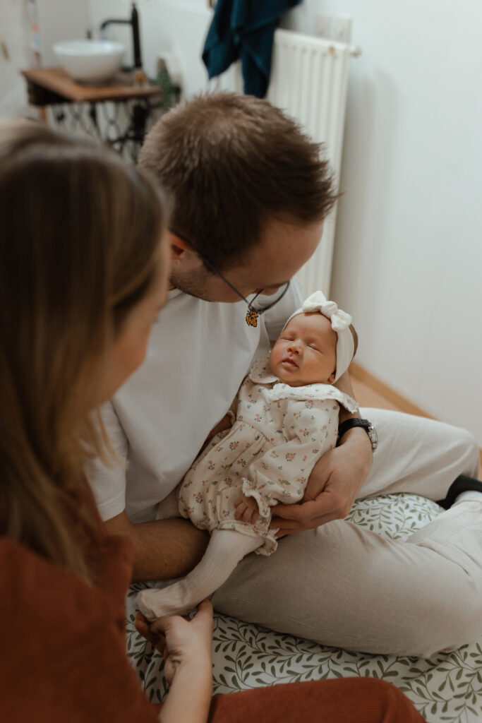 Parents regardant tendrement leur nouveau-né lors d'une séance photo à Reims.