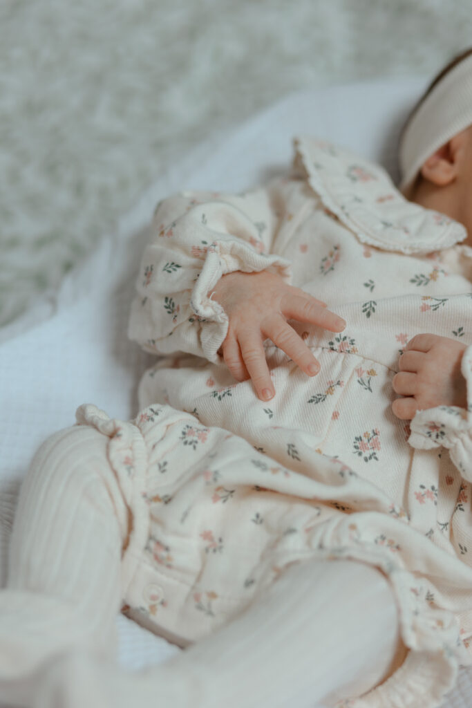 Gros plan détaillé de la main d'un nouveau-né lors d'une séance photo naissance à Reims.