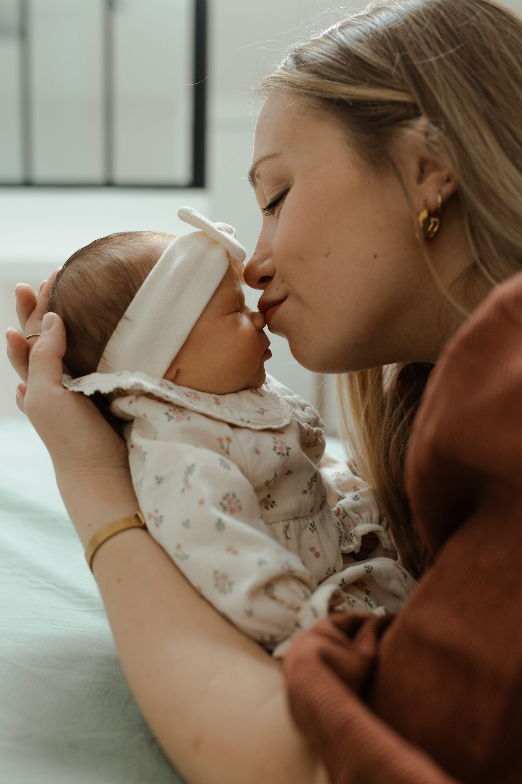 Gros plan : maman embrassant tendrement le nez de son bébé.