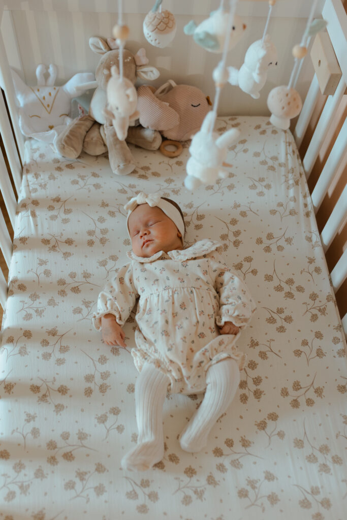 Nouveau-né endormi paisiblement dans son lit, décoration chambre bébé.