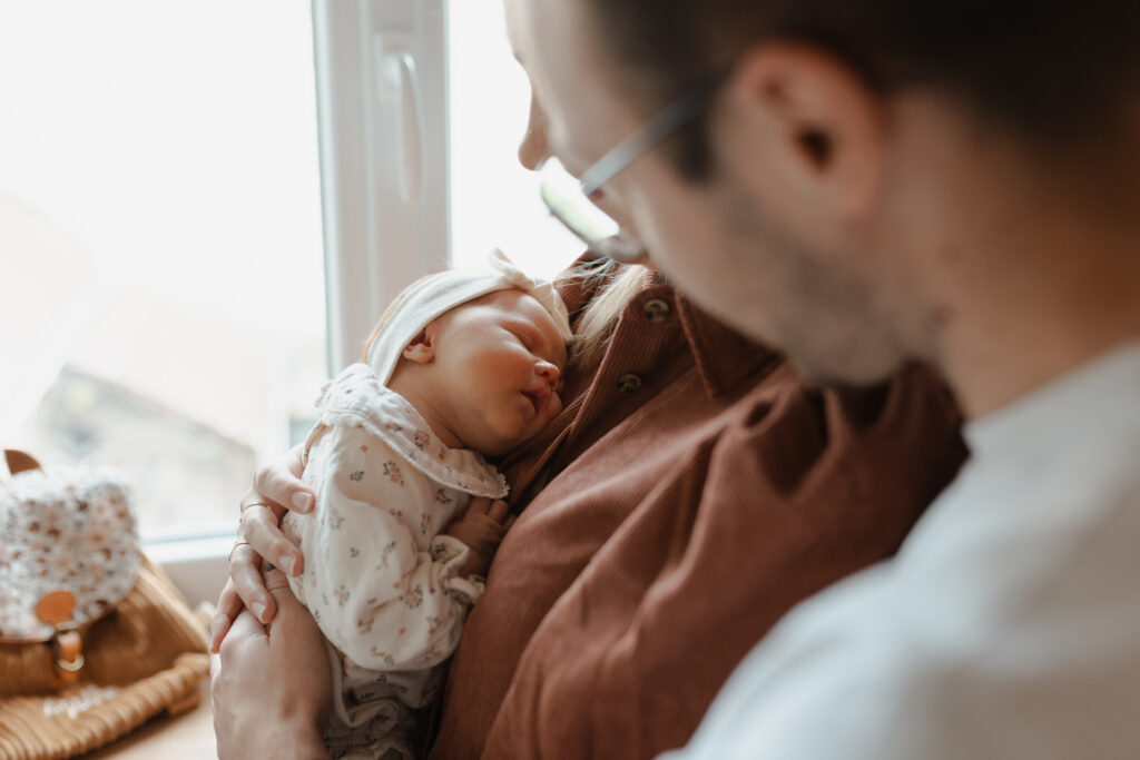 Gros plan en couleurs de la famille partageant un moment de tendresse avec leur nouveau-né à Reims.