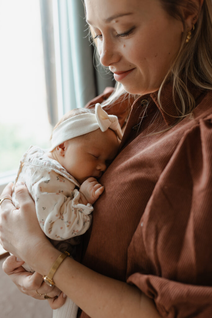 Portrait de maman portant son bébé endormi et le regardant avec un sourire tendre à Reims.
