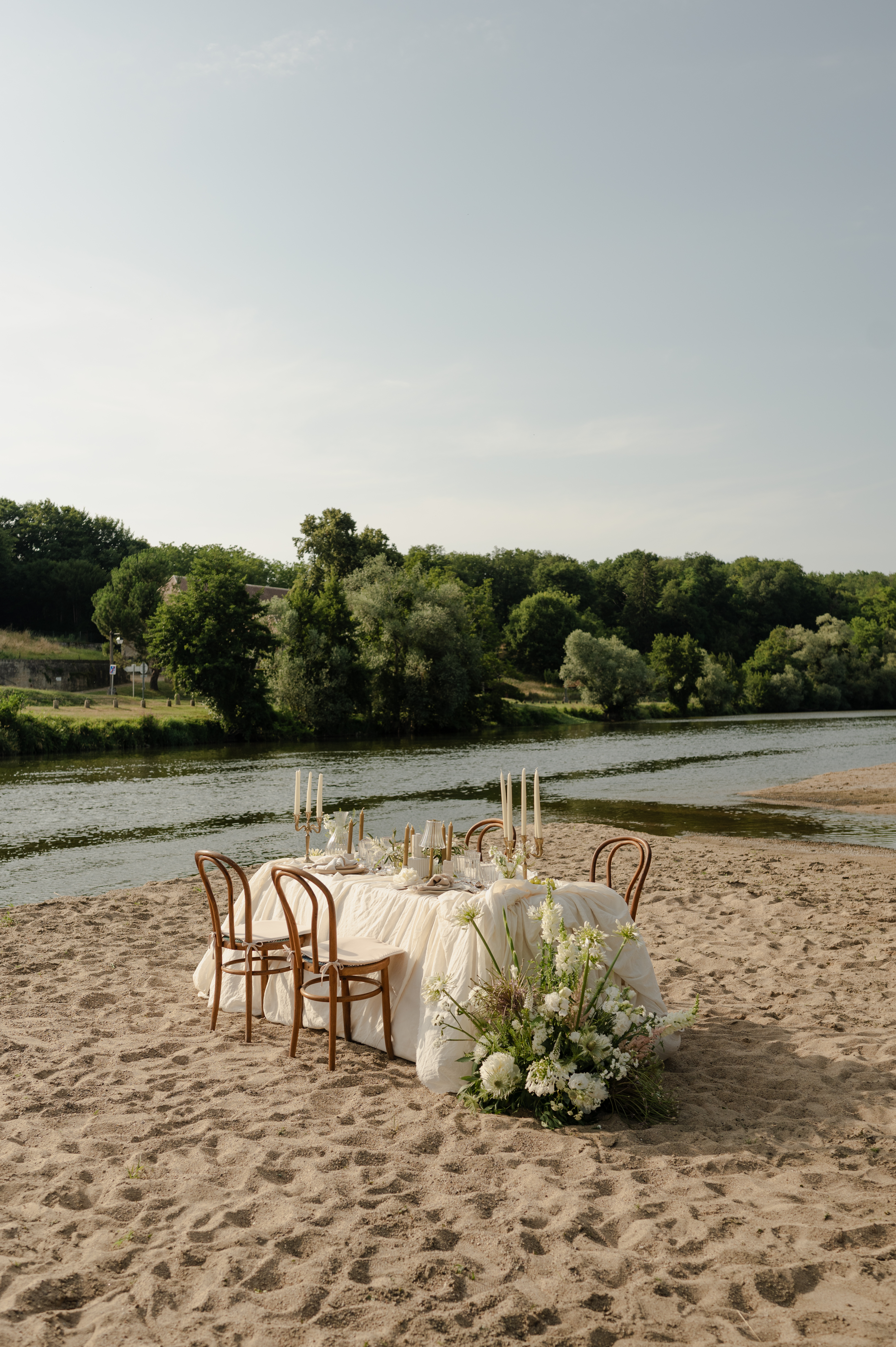 Table de mariage décorée en extérieur sur une plage de sable, mariage Nevers.